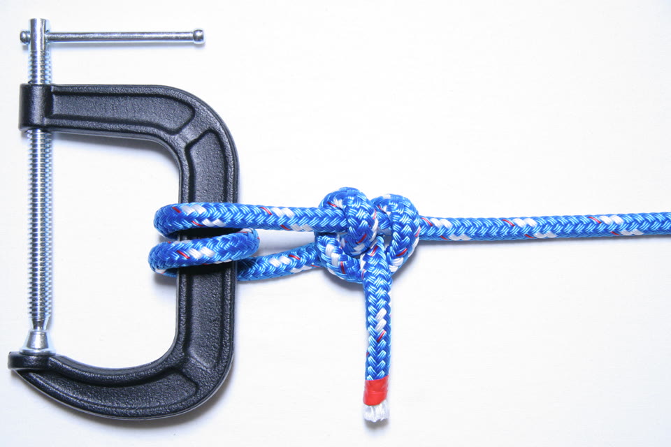 Photo of a finished round turn and two half hitches on the bar of a clamp