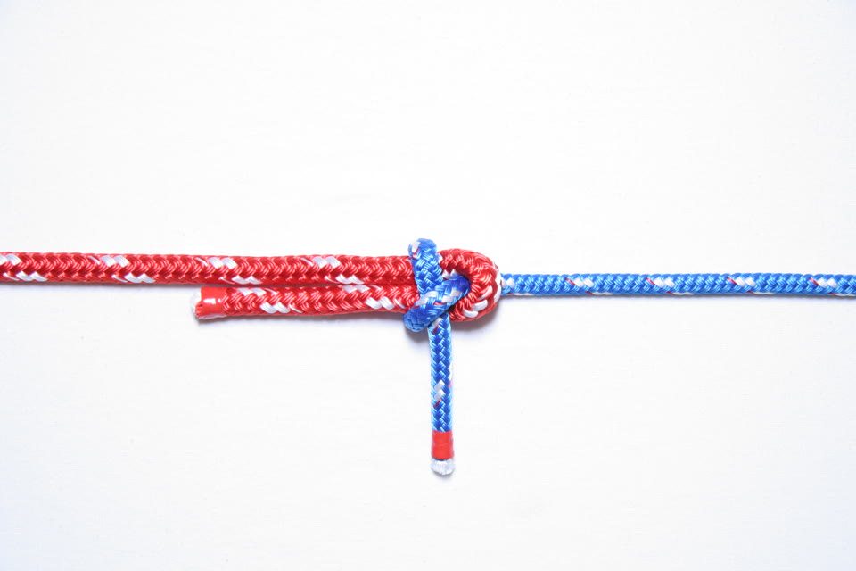 Photo of a finished sheet bend joining a thicker red line and a thinner blue line